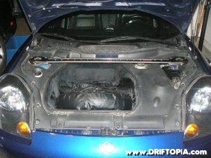 Jpg image of the TRD front strut tower brace installed with the frunk trim on the MR2 Spyder