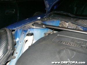 Jpg image showing the clearance issude  if the lid is not removed from the spare tire bin when installing the TRd front strut brace on the MR2 Spyder