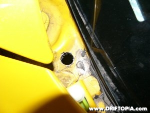 Jpg image showing the hole drilled behind the firewall to pass the wiring for the electric gauges through to the S2000’s engine bay.