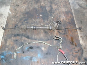 The feed and return lines removed from the steering rack on the Nissan 240sx.