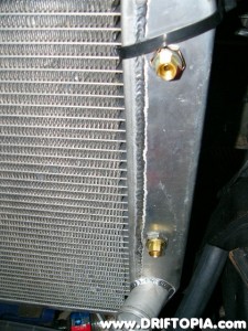 The 1/8" to 1/4" adapters installed in the transmission cooler of the radiator.
