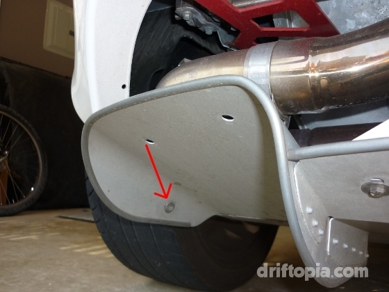 On either side of the rear splitter there is an 8mm bolt just to the side of the wheel well.