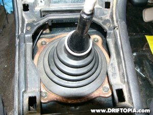 The upper shifter boot of the 240sx is exposed once the center plastic is removed.
