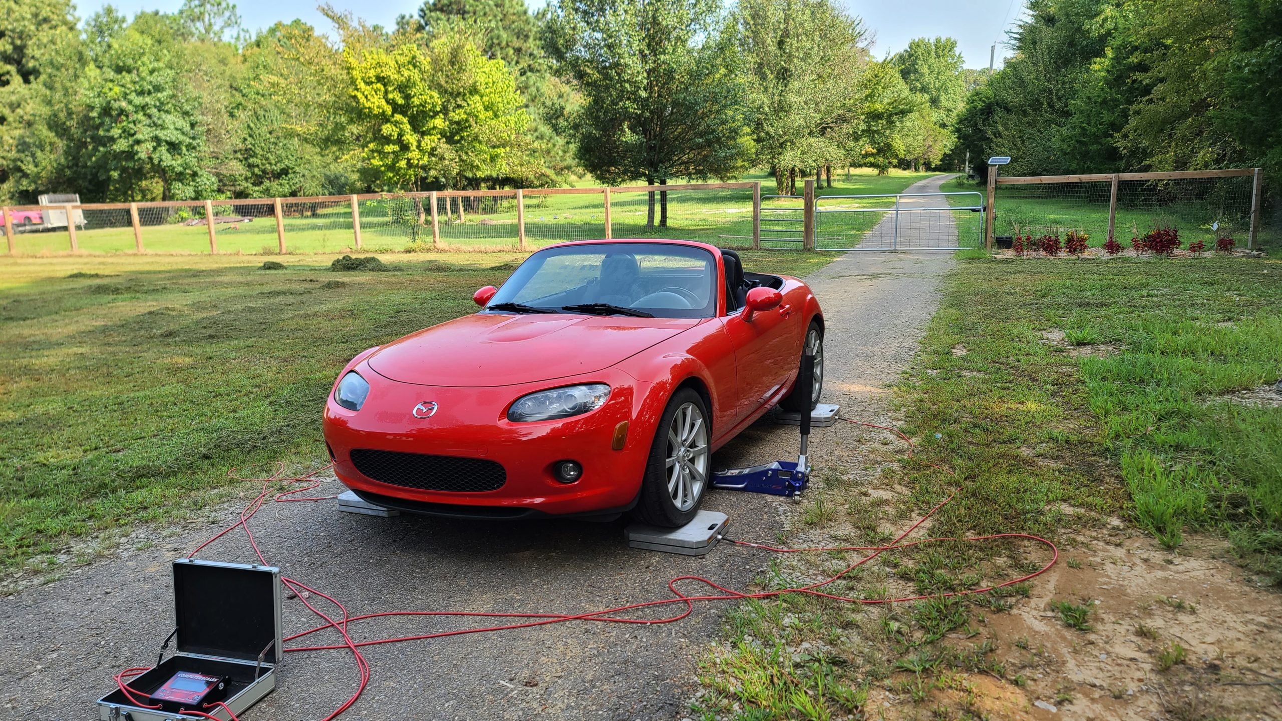 The NC MX-5 on longacre scales to calculate the overall weight of the car without driver and a full tank of gas.